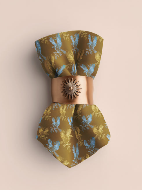 Set of four golden cloth napkins featuring alternating powder blue and metallic gold ravens in flight, sized 18x18 inches.